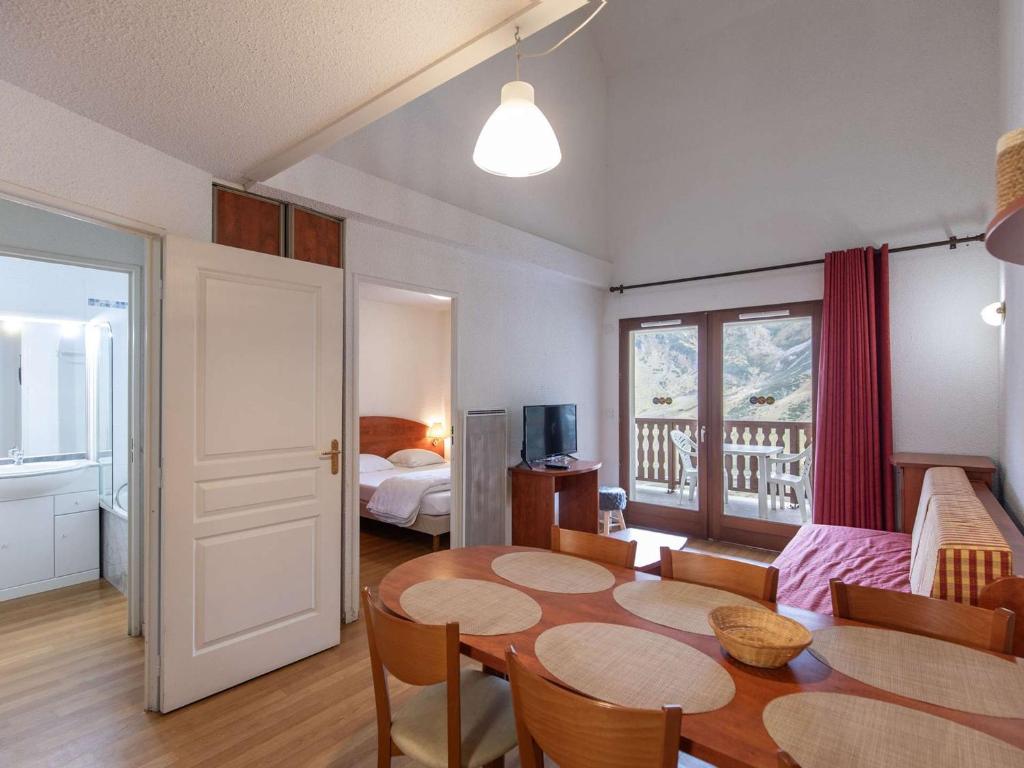 un salon avec une table et une chambre dans l'établissement Duplex 7 pers - Terrasse Sud, Piscine, Salle de Fitness, Proche Pistes - FR-1-404-197, à La Mongie