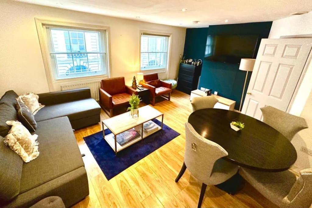 a living room with a couch and a table and chairs at H3: Fantastic Apt - 100m from Piccadilly Circus!! in London