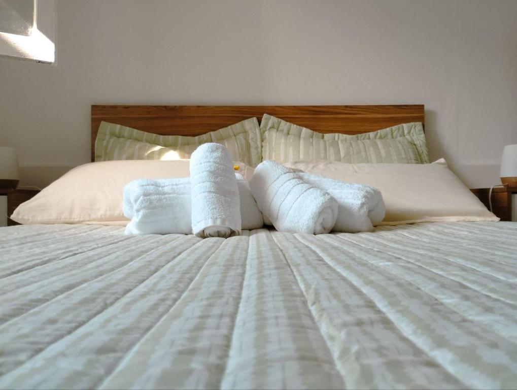 Una cama con dos rollos de toallas. en Hospedaje DCB en Capilla del Monte