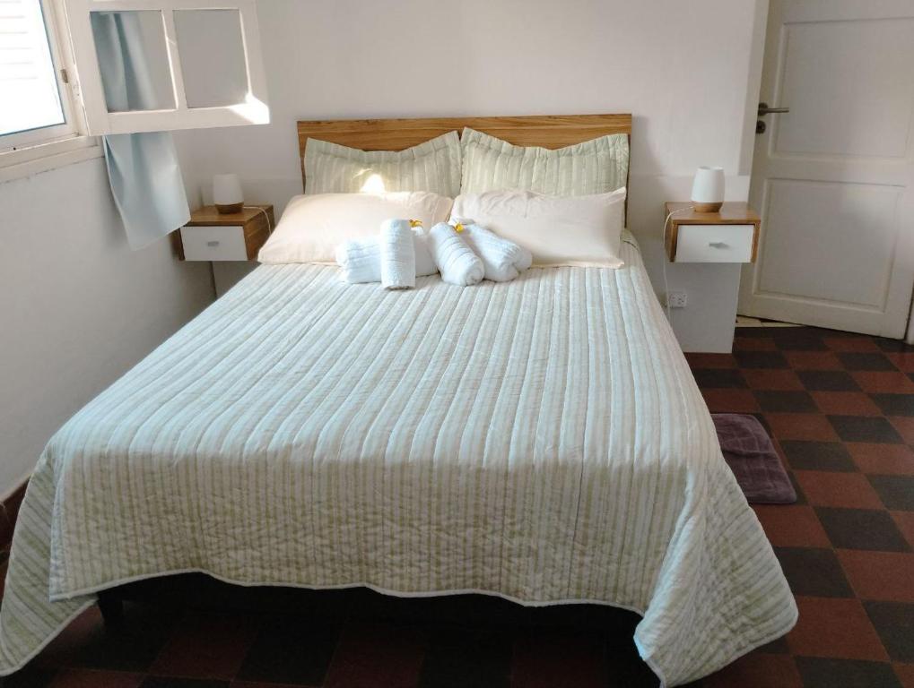 a bedroom with a large bed with two pillows at Hospedaje DCB in Capilla del Monte