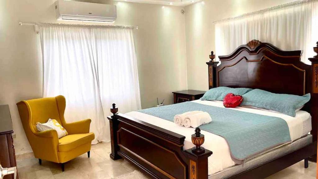 una camera con letto e sedia gialla di VILLA I-31 capacidad para 20 personas a Paraíso