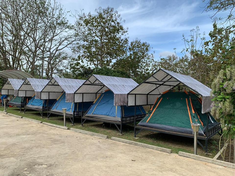 a row of tents parked in a row at Baan Suan Madam บ้านสวนมาดามวังน้ำเขียว in Ban Khlong Ta Sang