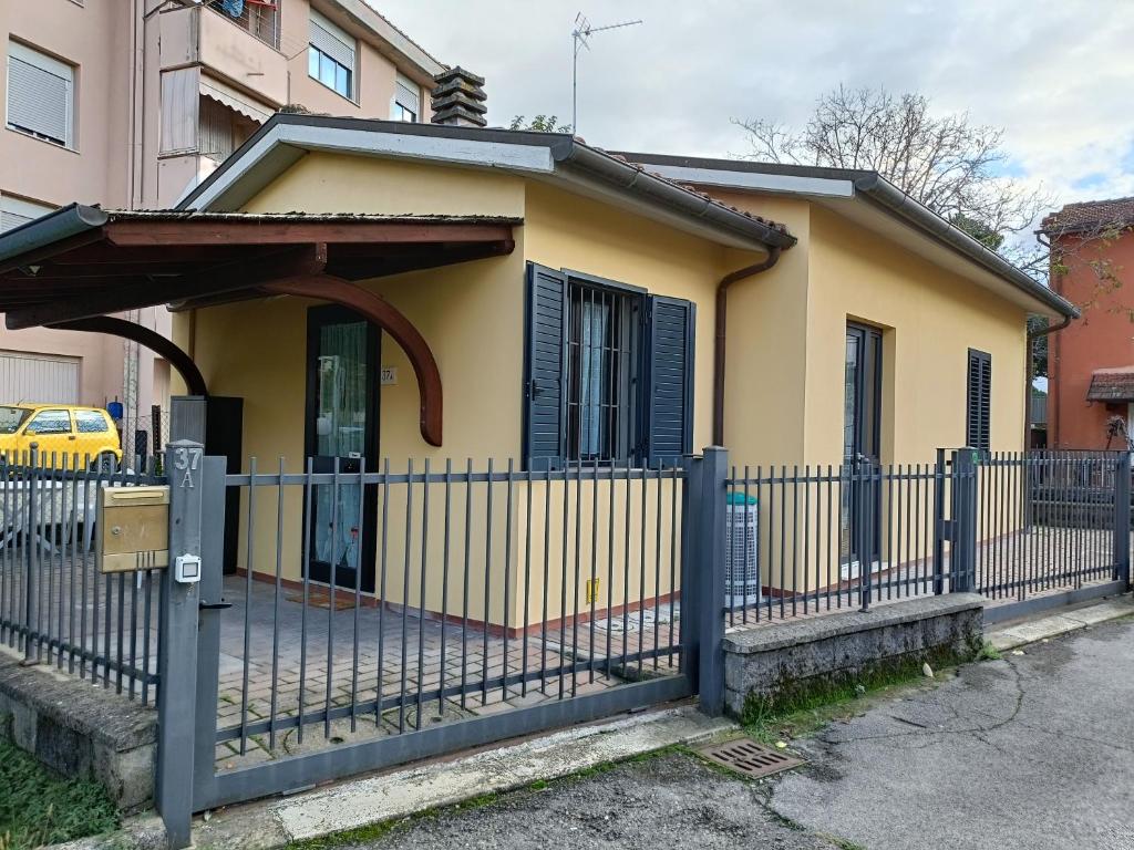 a small yellow house with a blue fence at A Casa di Amici in Arezzo