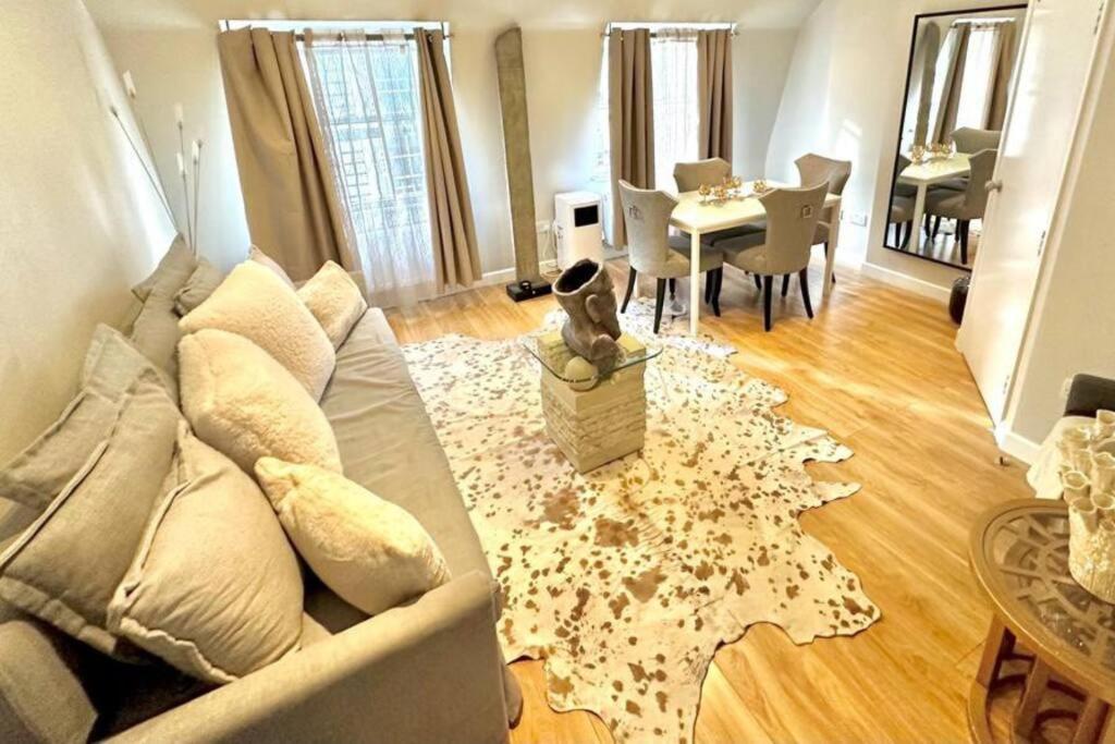 uma sala de estar com um sofá e um cão sentado num tapete em H4: Fantastic Apartment - 100m from Piccadilly Circus em Londres