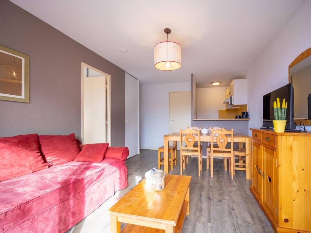 a living room with a red couch and a table at Appartement Peyragudes, 2 pièces, 6 personnes - FR-1-695-9 in Germ