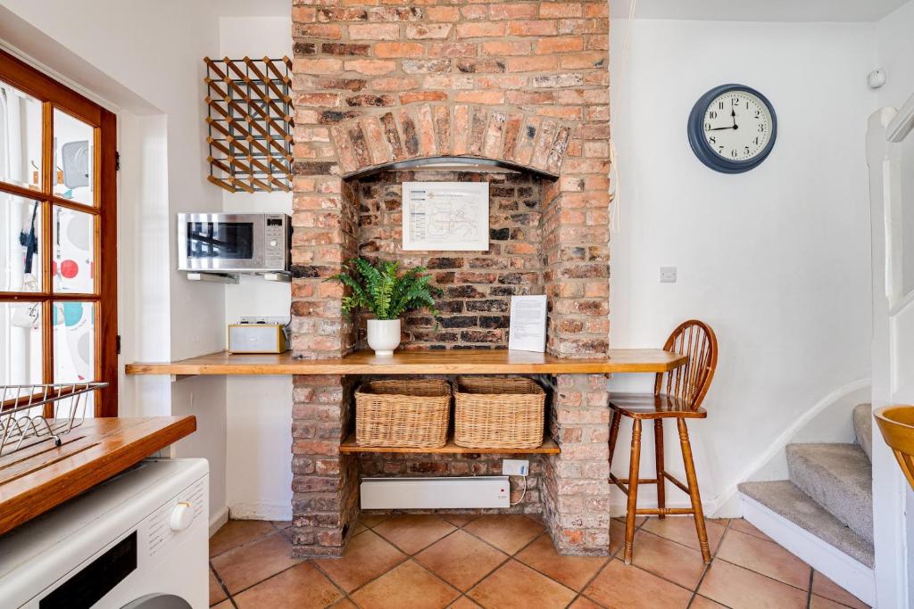 una chimenea de ladrillo en una cocina con mesa y sillas en Gamul Place - Quiet City Centre, en Chester