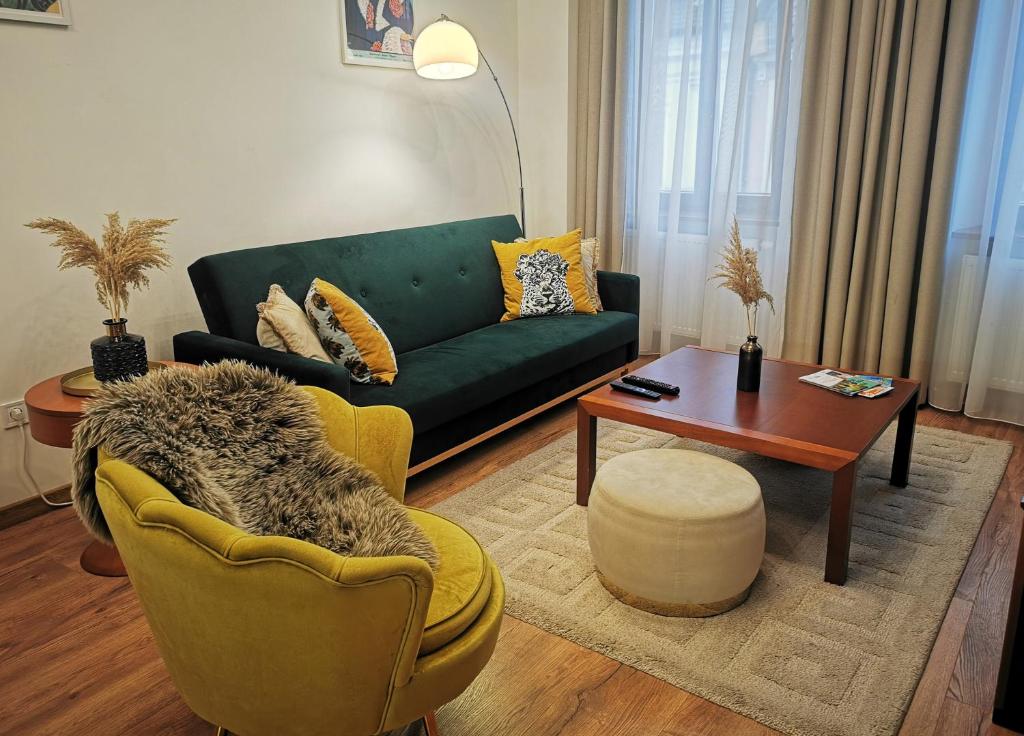 uma sala de estar com um sofá verde e uma mesa em Atlas Apartment in the historical center of Košice with free private parking em Košice