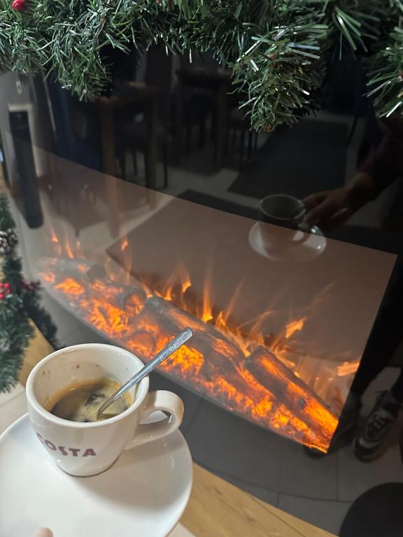a cup of coffee sitting on a table next to a fire at Villa Ivan & Petar in Semkovo