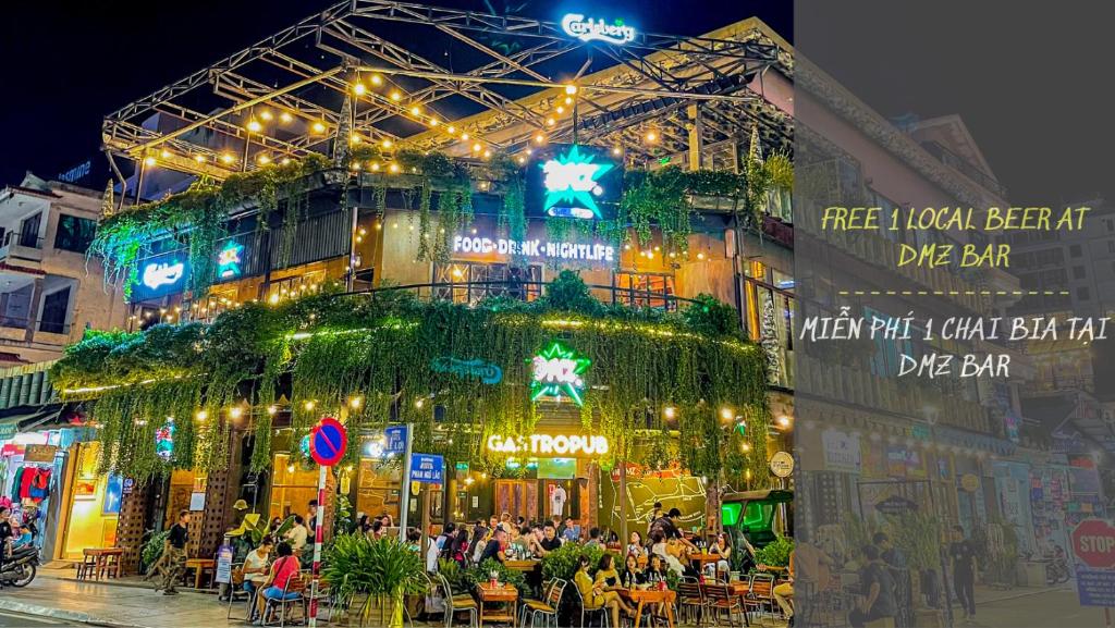 a building with people sitting outside of it at night at DMZ Hostel in Hue