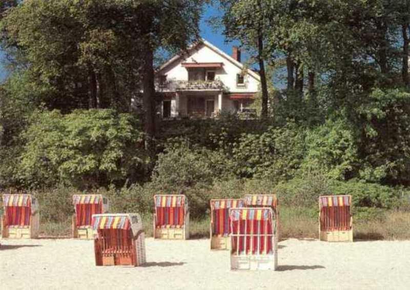 eine Gruppe von Stühlen im Sand vor einem Haus in der Unterkunft Haus am Hang Pension garni in Scharbeutz