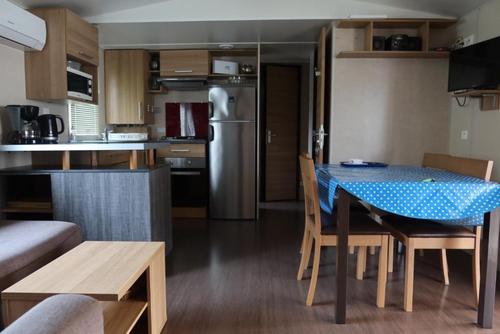 a kitchen and dining room with a table and chairs at GHVacances PiPiou Lac de Parentis en Born in Parentis-en-Born