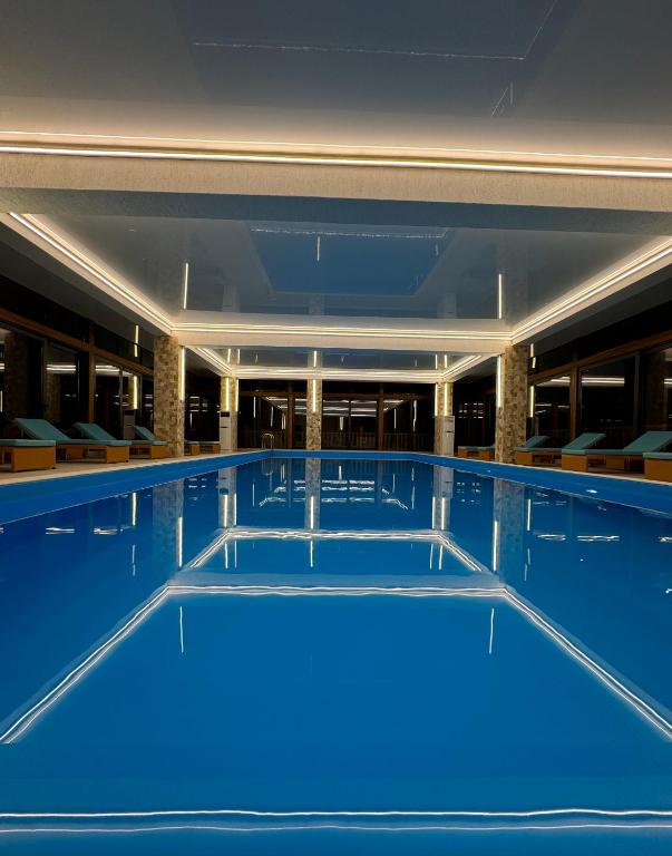a large swimming pool with blue water at Gistola Hotel Mestia in Mestia