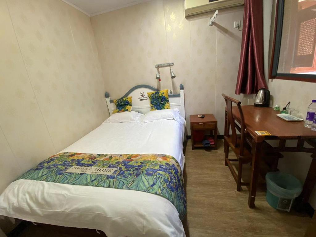 una camera con letto, scrivania e di Shaoxing Laotaimen Luxun Native Place Youth Hostel a Shaoxing