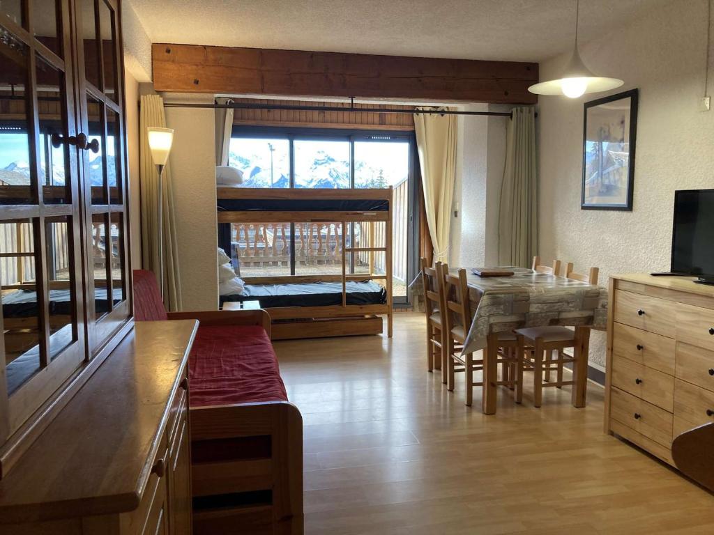 ein Wohnzimmer mit einem Tisch und einem Esszimmer in der Unterkunft Appartement Huez, 1 pièce, 4 personnes - FR-1-405-19 in L'Alpe-d'Huez