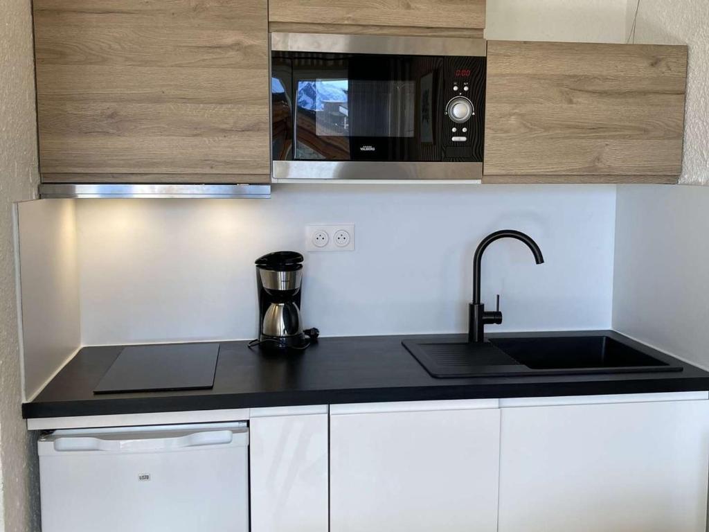 a kitchen with a sink and a microwave at Appartement Huez, 1 pièce, 4 personnes - FR-1-405-24 in L&#39;Alpe-d&#39;Huez