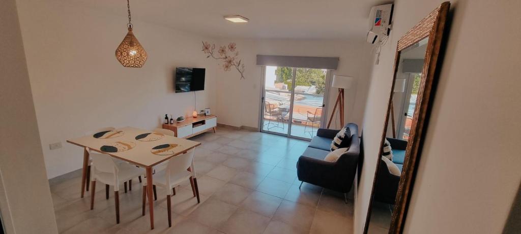 a dining room and living room with a table and chairs at Amma Selva Temporarios in Posadas