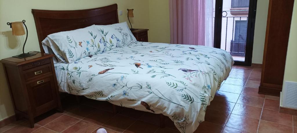 a bed with a white comforter with fishes on it at La belleza del Tietar in Lanzahita