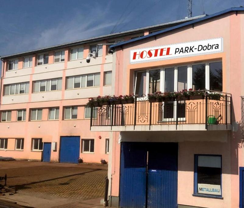 een roze gebouw met een balkon en een hotel bij HOSTEL PARK-Dobraszczecińska in Szczecińska