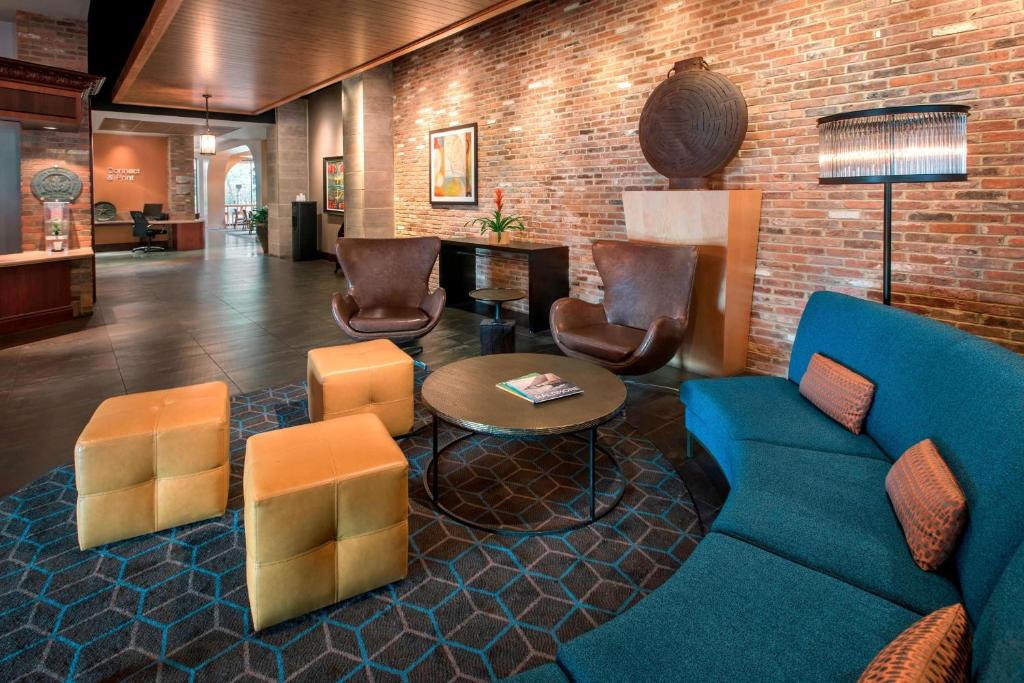 a lobby with a blue couch and chairs and a brick wall at Fairfield inn & Suites by Marriott Baltimore Downtown/Inner Harbor in Baltimore