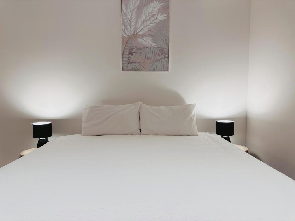 Una cama blanca con dos almohadas encima. en Skyscape Spectacle 3Bedrooms Panorama Views, en Brisbane