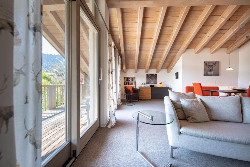 - un salon avec un canapé et une grande fenêtre dans l'établissement Partnachauen, à Garmisch-Partenkirchen
