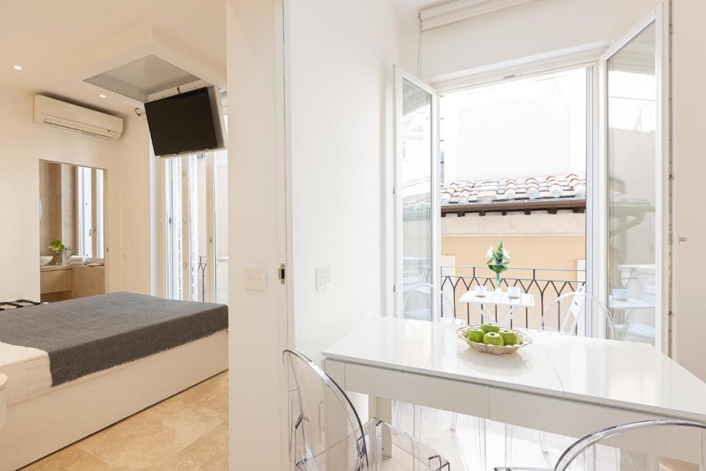 a white apartment with a bed and a table and chairs at Amazing Cozy Piazza Venezia in Rome