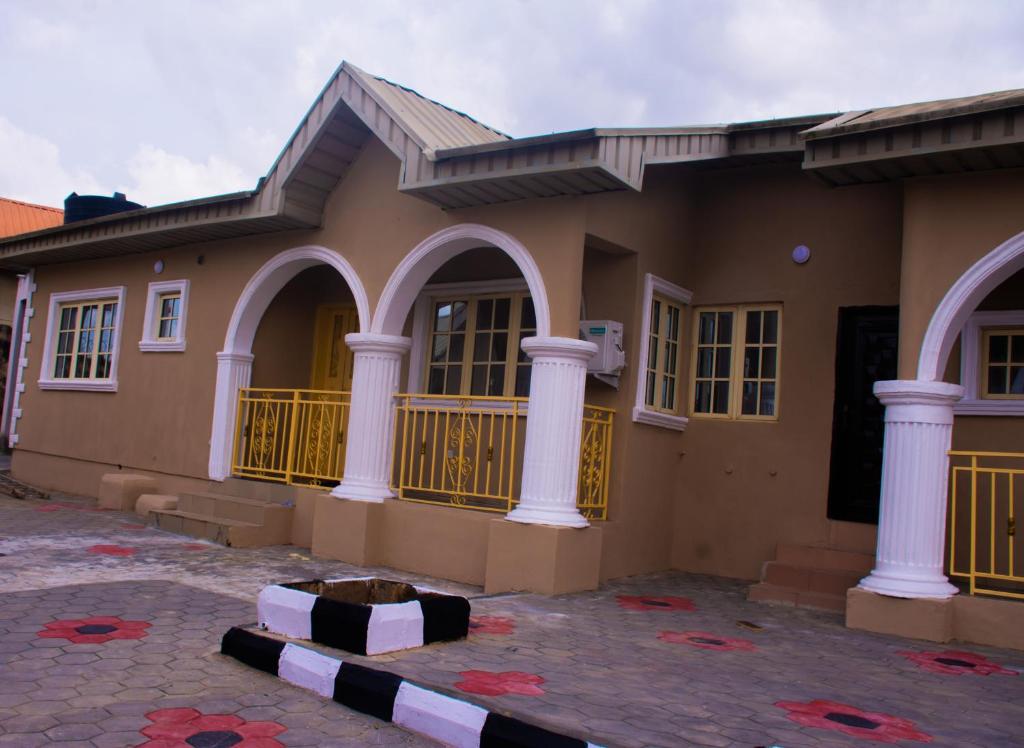 ein Haus mit Säulen davor in der Unterkunft Xproject Homes in Ibadan