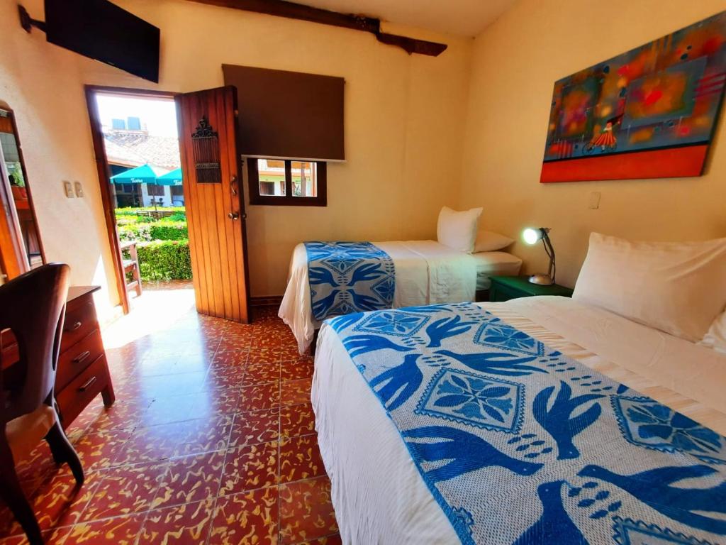 ein Hotelzimmer mit 2 Betten und einem TV in der Unterkunft Hotel La Posada del Doctor in León