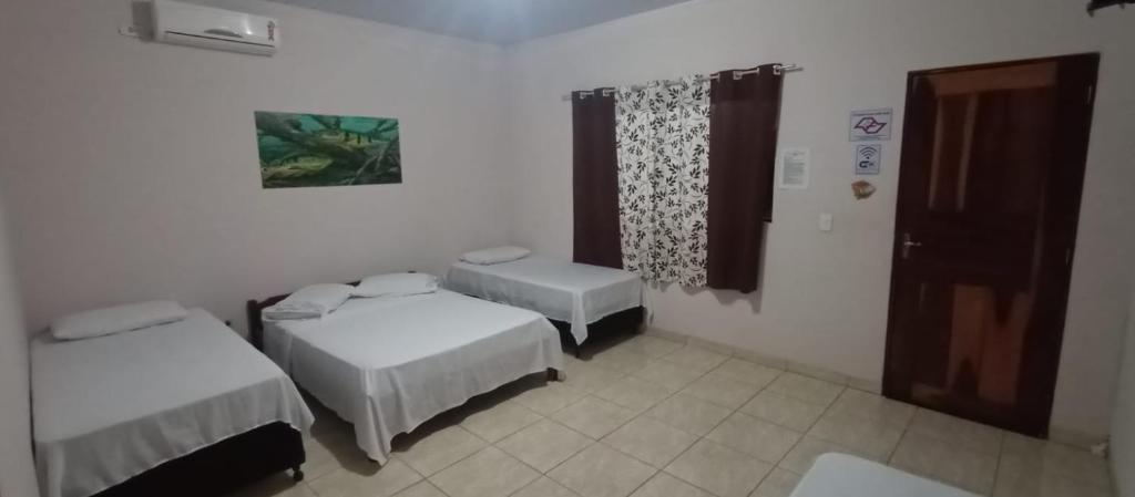 Zimmer mit 2 Betten und einem Fenster in der Unterkunft HOSPEDARIA TUCUNA in Presidente Epitácio