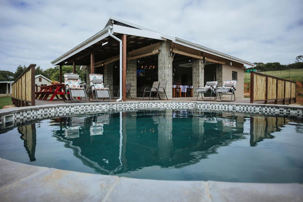 a swimming pool in front of a house at Rockdell Lodge in Stutterheim