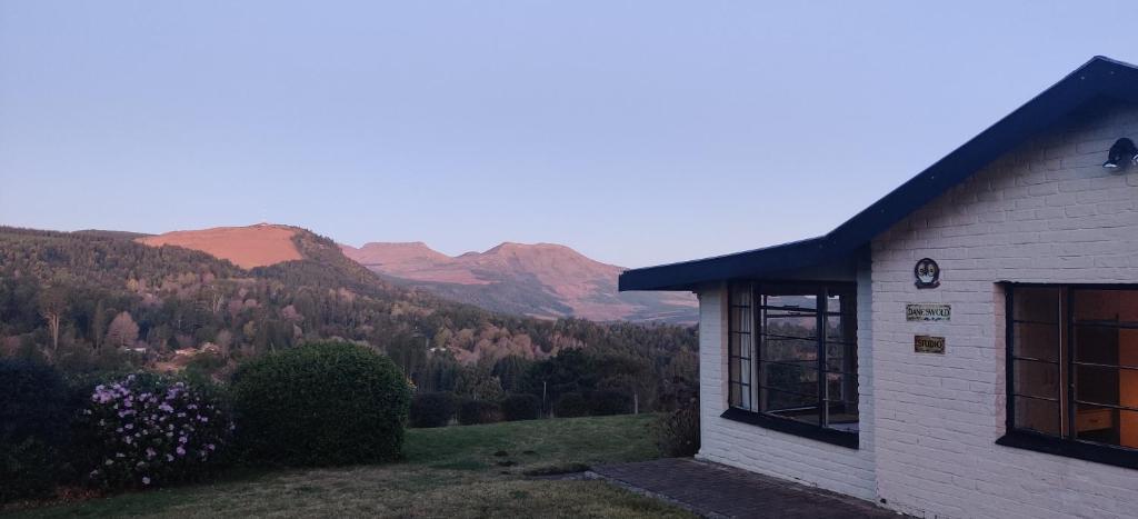 a white building with a view of the mountains at Daneswold Country Cottage and Manor House in Hogsback