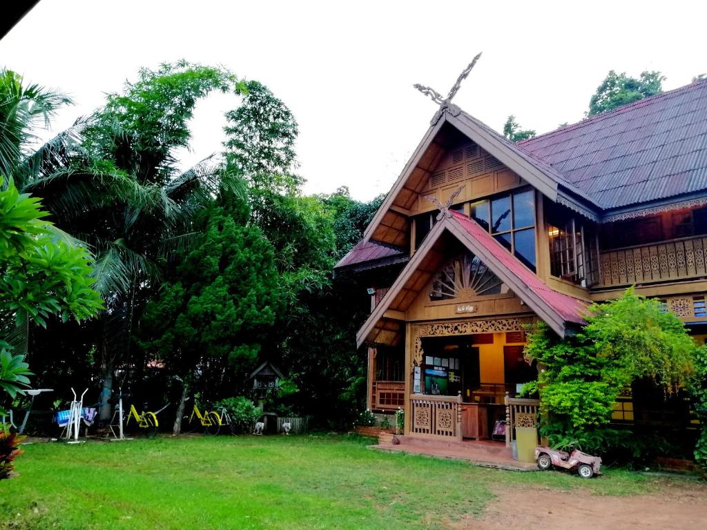 uma casa com um moinho de vento na frente dela em Crossroads house em Mae Hong Son