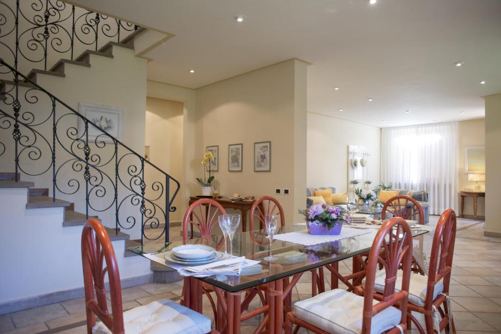 a dining room with a glass table and chairs at Villa La Bouganville Versilia in Marina di Pietrasanta