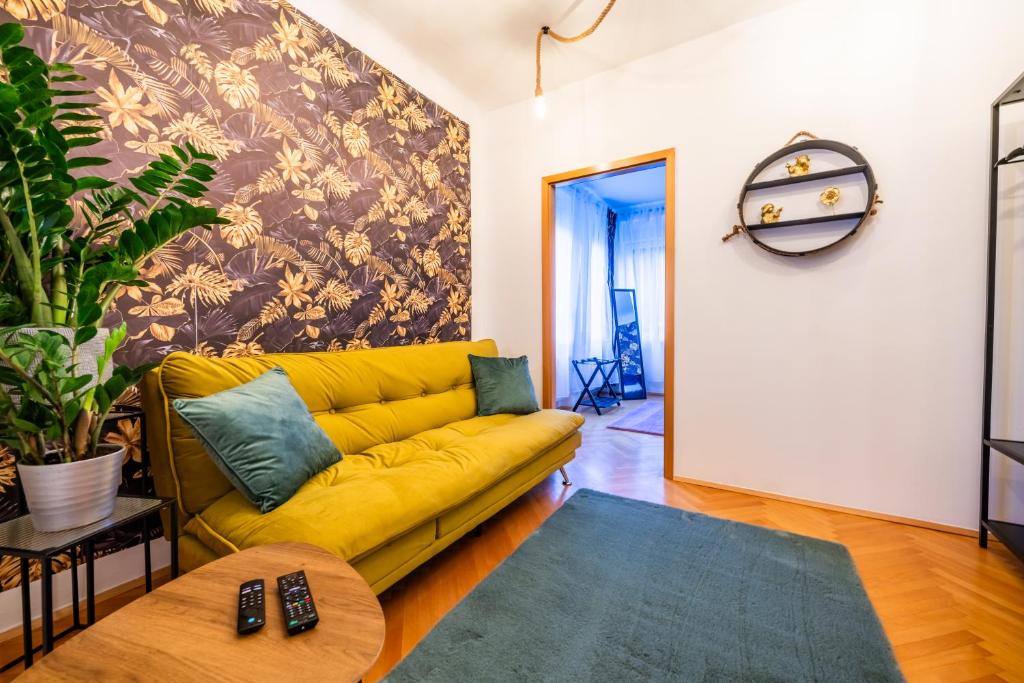a living room with a yellow couch and a table at Modernes Appartement in Graz