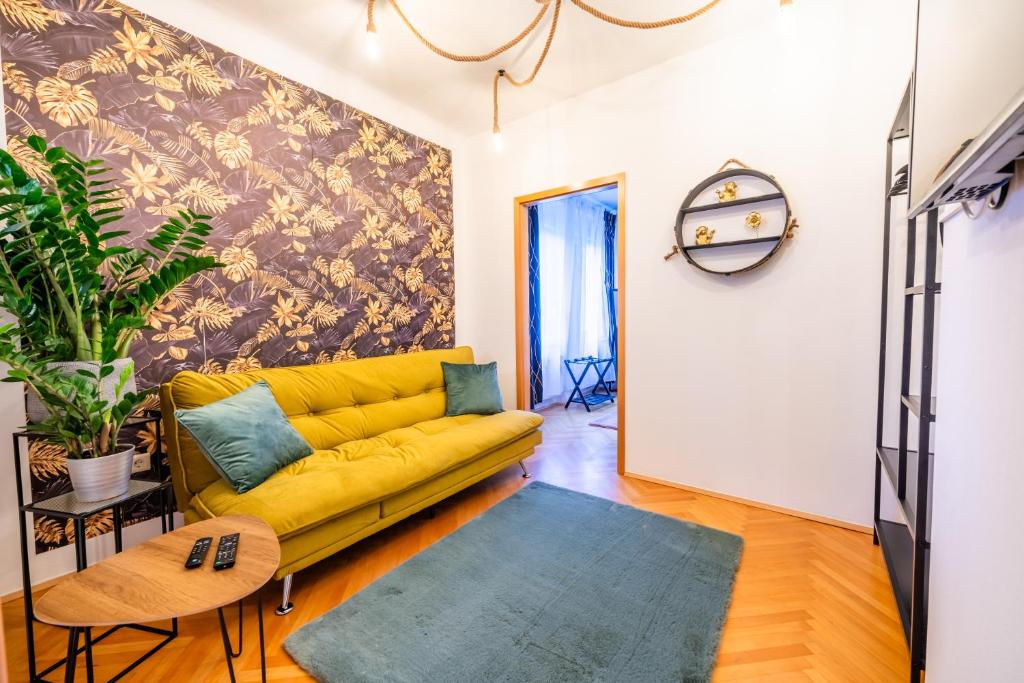 um sofá amarelo numa sala de estar com uma parede em Modernes Appartement em Graz