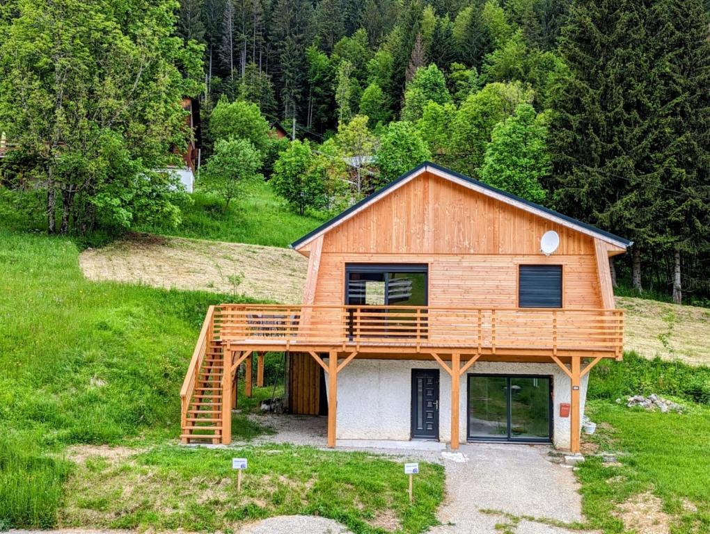 une maison avec une terrasse au sommet d'une colline dans l'établissement Chalet les Iris, à Le Massot