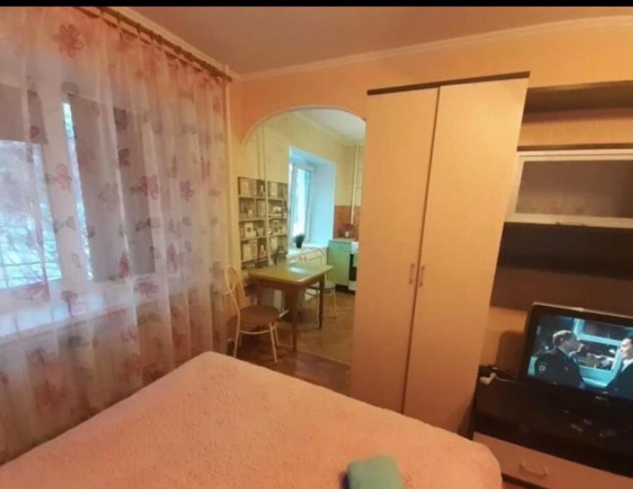 een slaapkamer met een bed, een tv en een bureau bij VIP apart 339 in Tbilisi City