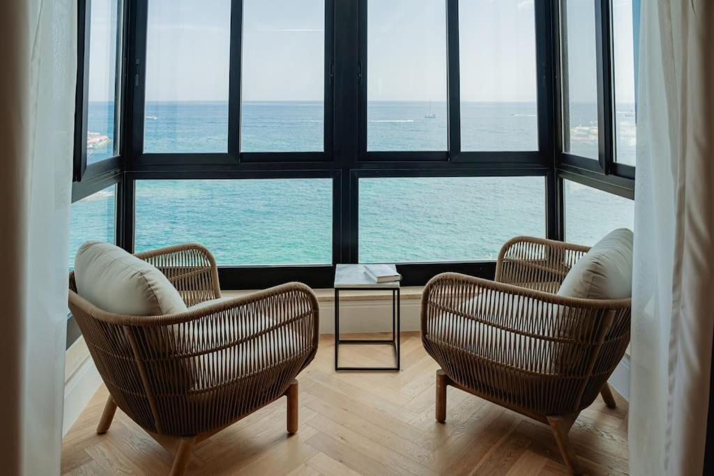 2 sillas y una mesa frente a una gran ventana en Seaside at Qui Si Sana, en Sliema