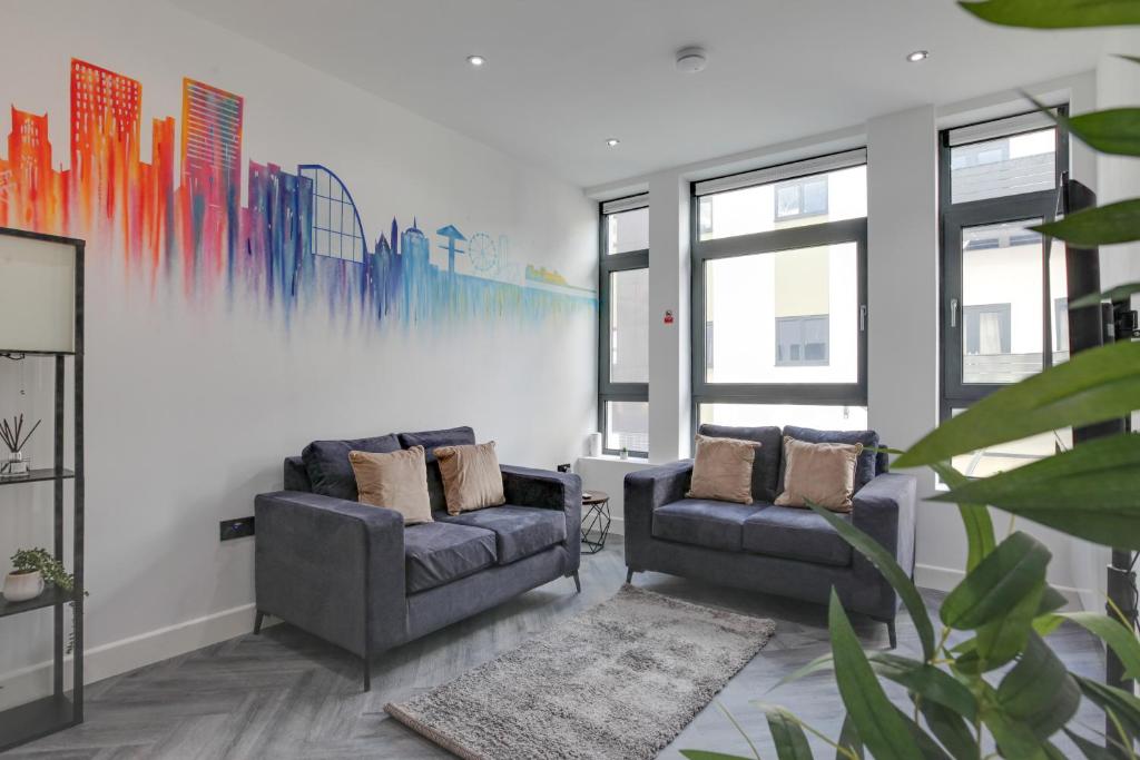 a living room with two chairs and a painting on the wall at CityView Executive Apartments Southend in Southend-on-Sea