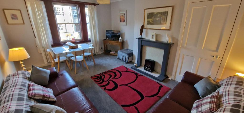 a living room with a couch and a fireplace at Morris Terrace Apartment in Stirling