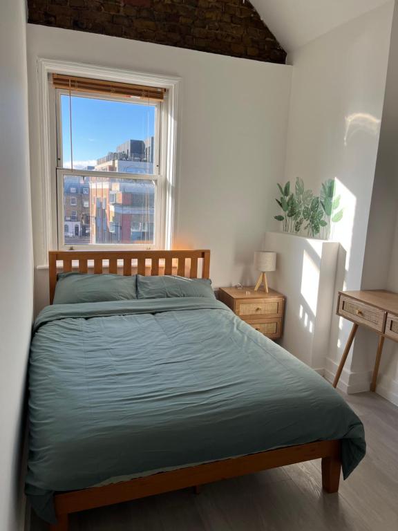um quarto com uma cama e uma grande janela em Camden BNB em Londres