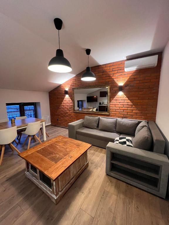 a living room with a couch and a table at Apartamenty na Maja - 6 in Skierniewice