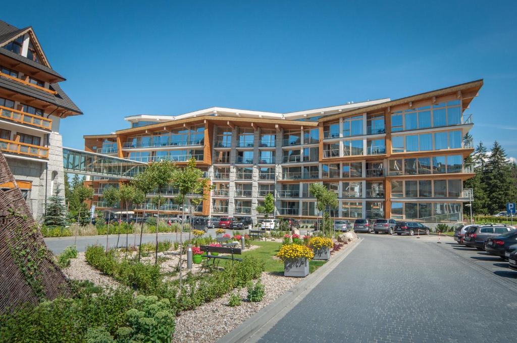 a large building with cars parked in a parking lot at Rezydencja Nosalowy Dwór in Zakopane