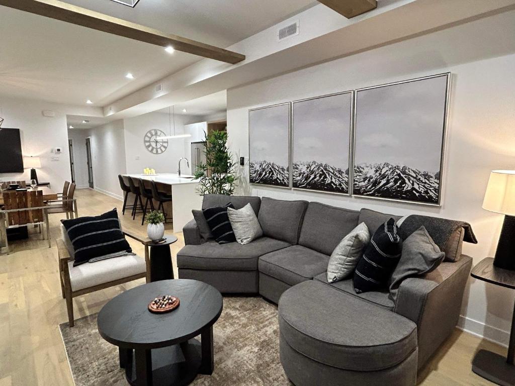 ein Wohnzimmer mit einem Sofa und einem Tisch in der Unterkunft Verbier New Luxurious Condo 2bdrm spa-pool-sauna in Mont-Tremblant