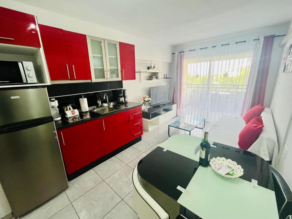 una cucina con armadi rossi e un tavolo di Santa Maria Ocean View ad Adeje