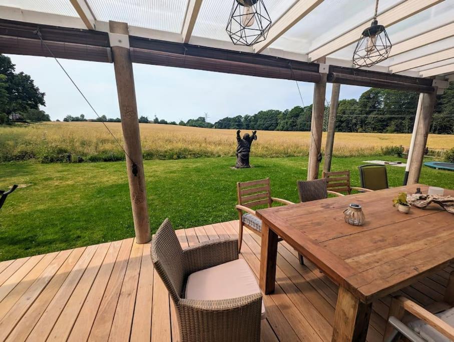 a wooden deck with a table and chairs and a statue at Ferienhaus Seestern in Reinbek in Reinbek