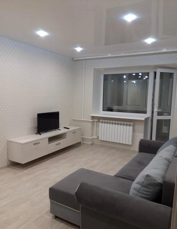 uma sala de estar com um sofá e uma televisão de ecrã plano em VIP apart 342 em Tbilisi
