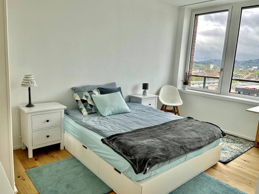 biała sypialnia z łóżkiem i oknem w obiekcie Lokstadt w mieście Winterthur