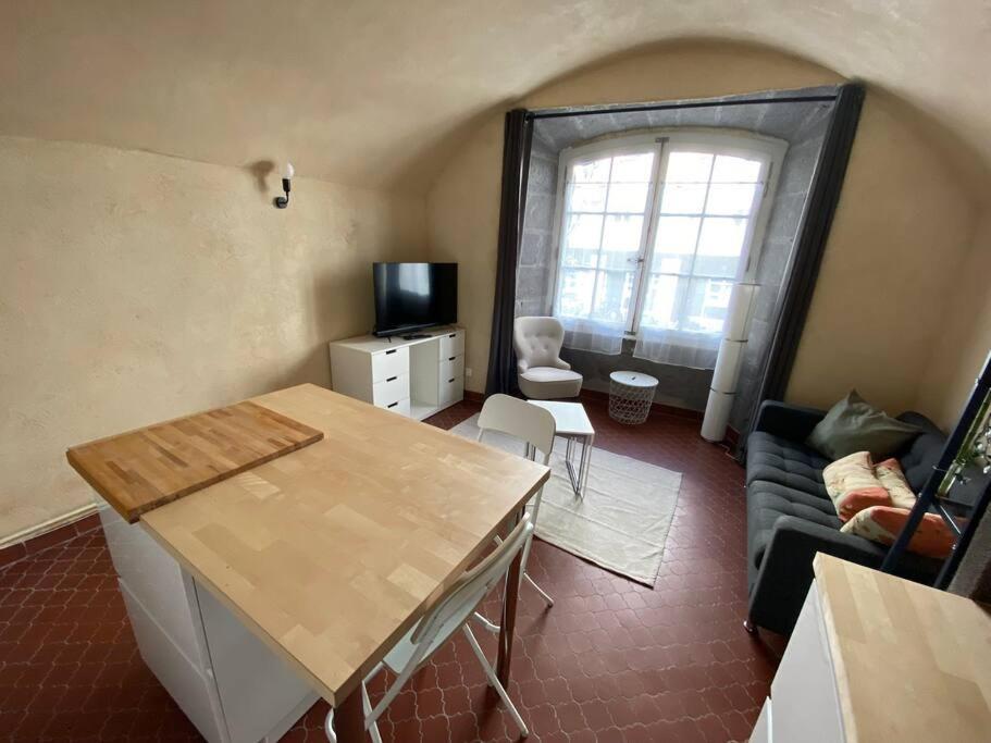 un salon avec une table et un canapé dans l'établissement NEW Grand Studio Plein centre Clermont-Ferrand, à Clermont-Ferrand