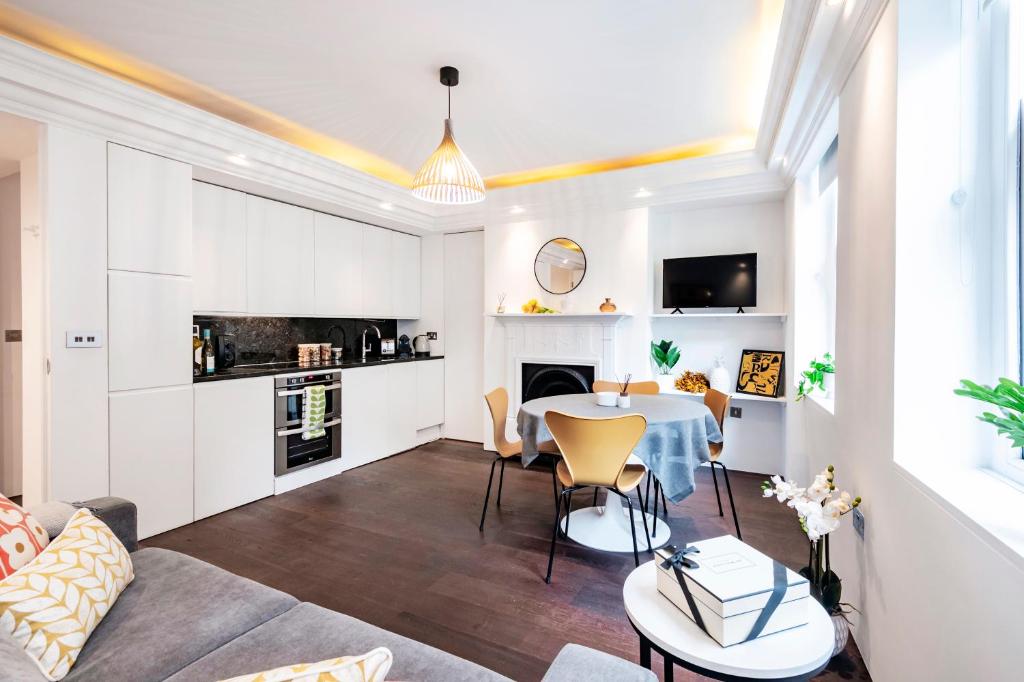 eine Küche und ein Wohnzimmer mit einem Tisch und Stühlen in der Unterkunft Welcome London Covent Garden in London